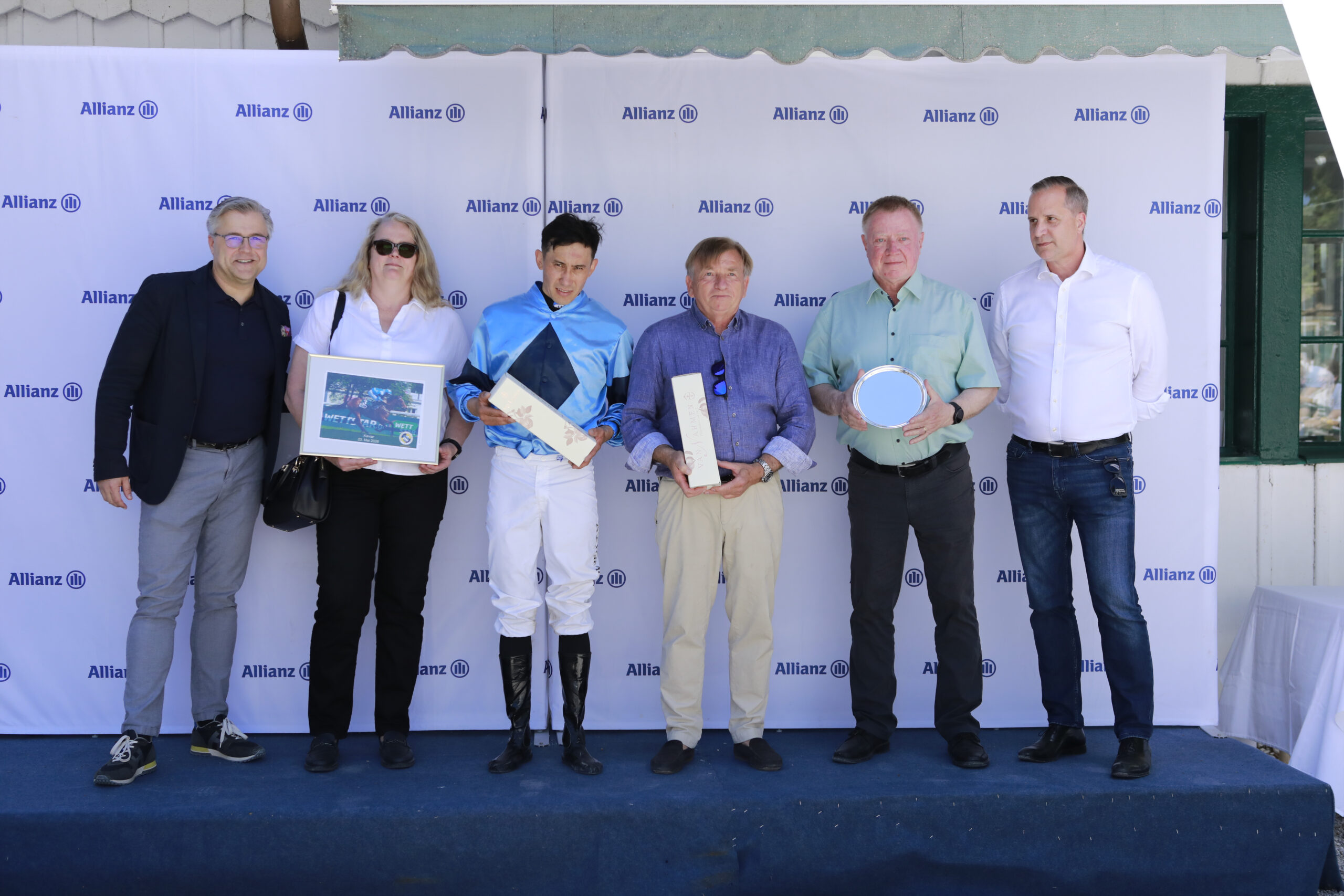 23.05.2026 - Munich; Winners presentation with Sascha Multerer (General Secretary Muenchener Rennverein e.V.), Jeanine Gindner, Bauyrzhan Murzabayev, Werner Glanz, Uwe Gindner and representative of the sponsor after winning the Preis vom VD Mayr with Kaviar at Munich-Racecourse/Germany. Credit: Lajos-Eric Balogh/turfstock.com